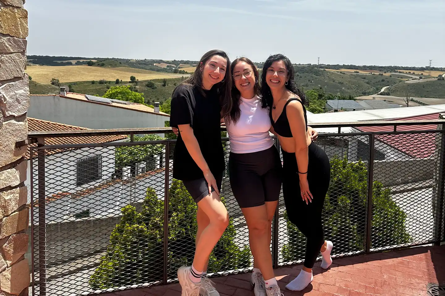 Tres colaboradoras de Natalia Pitarch sonriendo juntas en una terraza con vistas al campo