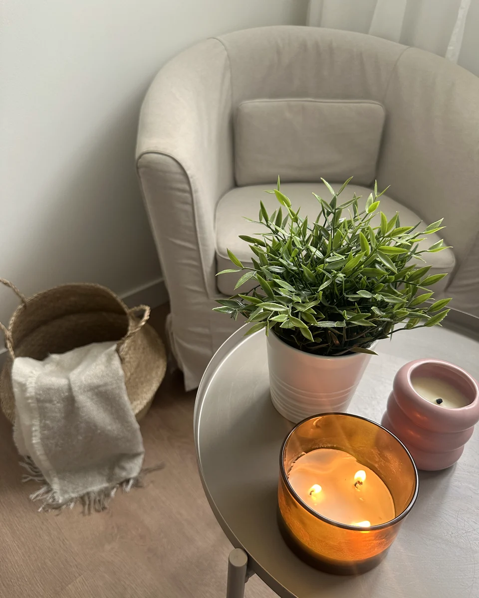 Sillón de la consulta junto a una mesa con una planta y velas encendidas